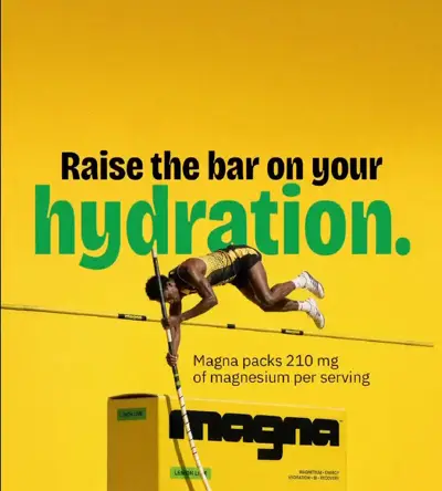 Magna reklamı: Raise the bar on your hydration, sırıkla atlayan atlet çıtayı Magna kutusunun üstünden aşıyor
